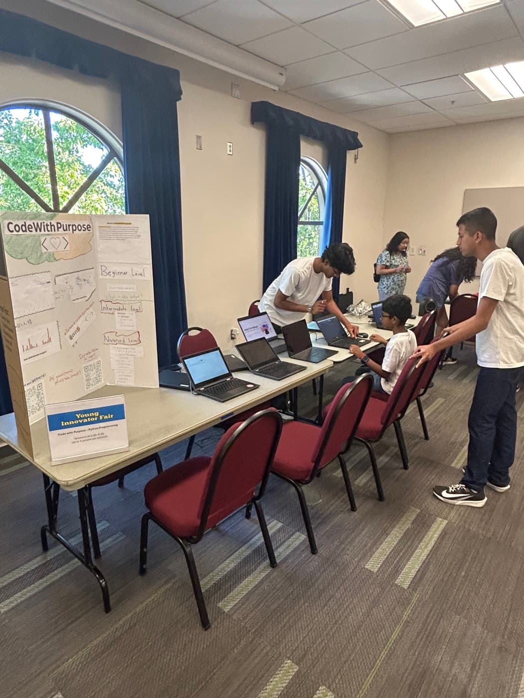 Volunteer helping a student at their laptop
