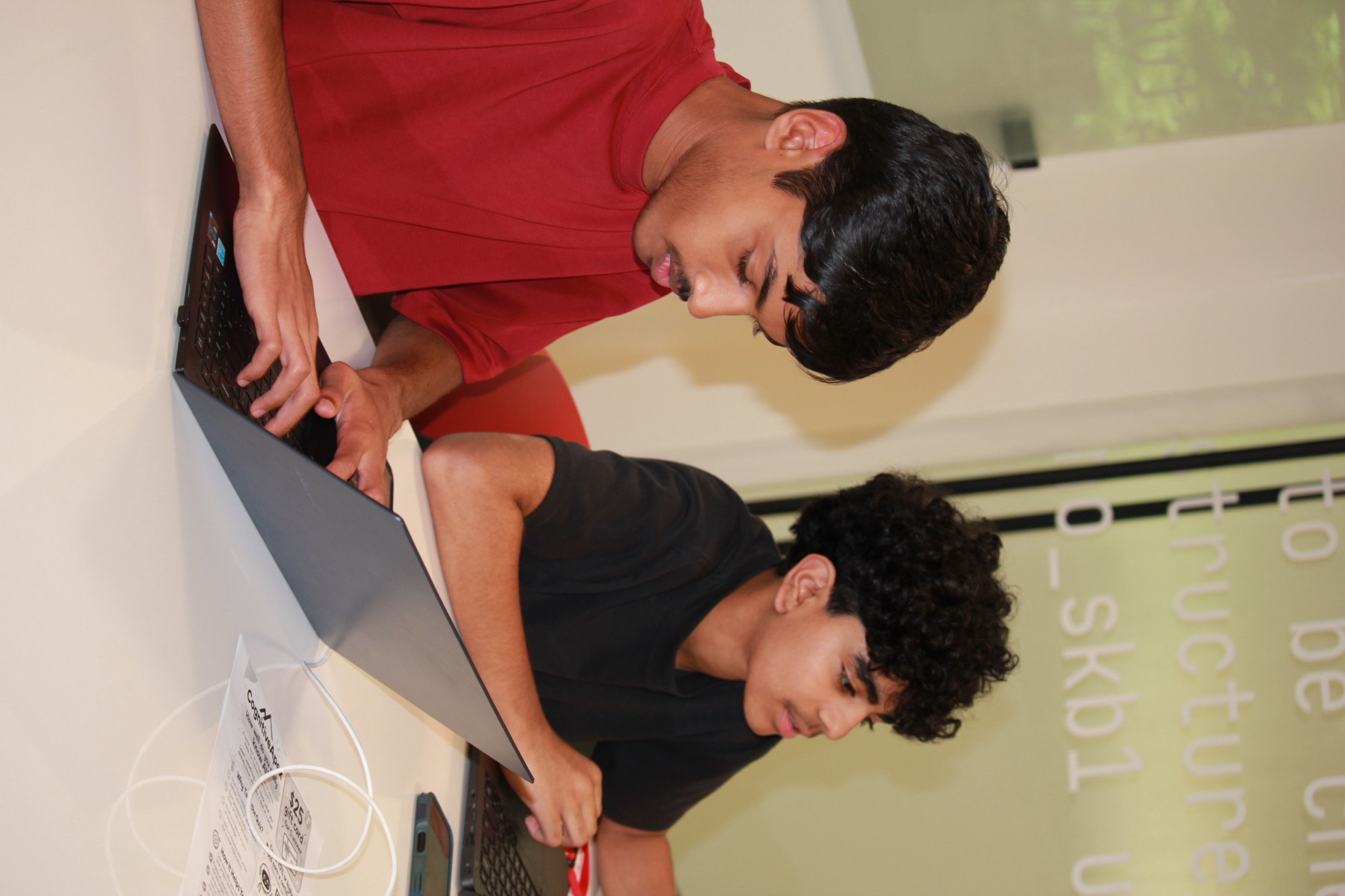 Two students work side by side on their laptops at the Dublin hackathon