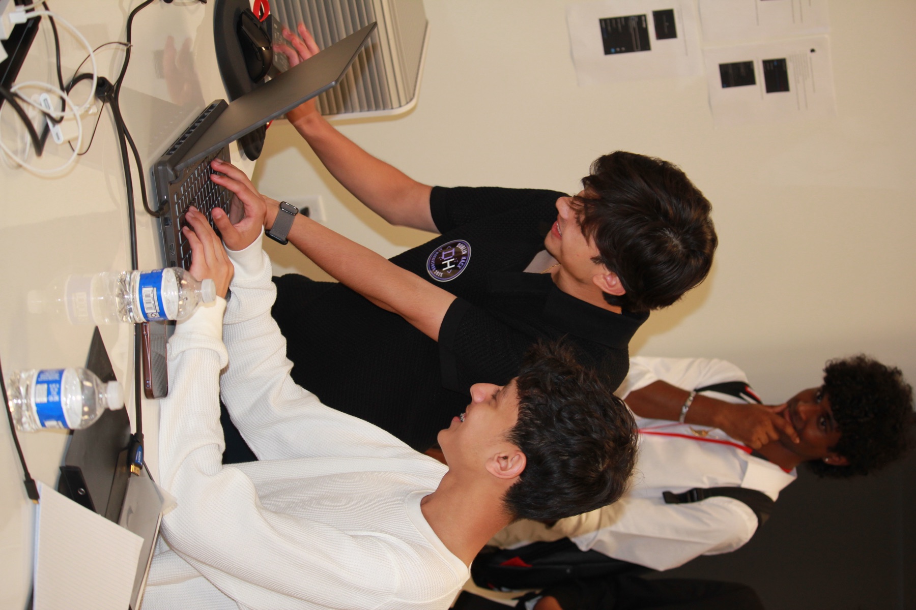 Students collaborate around a laptop at the Dublin hackathon